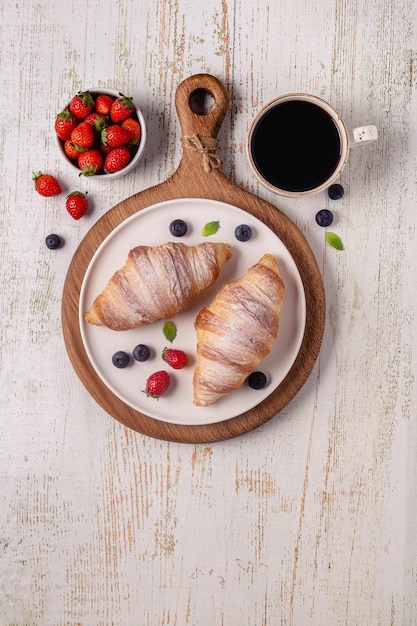 Café da manhã com croissants e vista superior de frutas frescas