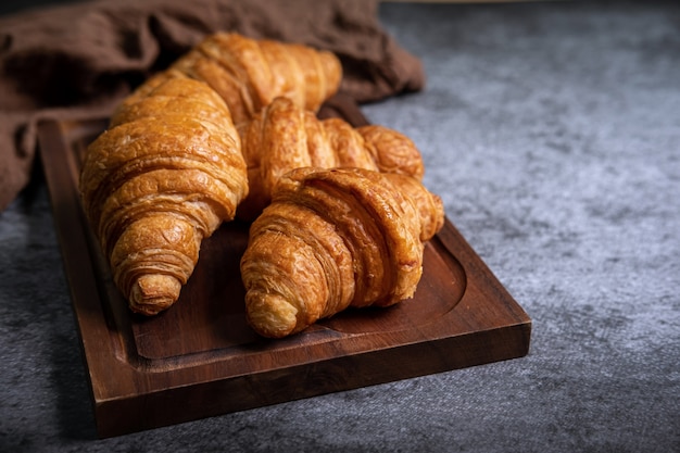 Café da manhã com croissants frescos na placa de madeira