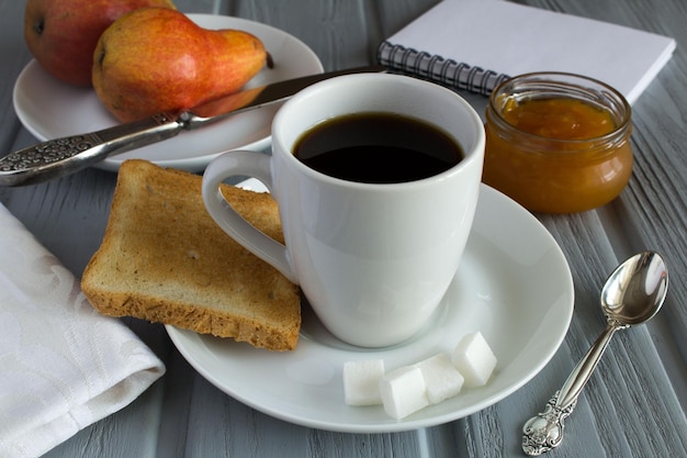 Café da manhã com geléia de torradas e pêra no fundo cinza de madeira