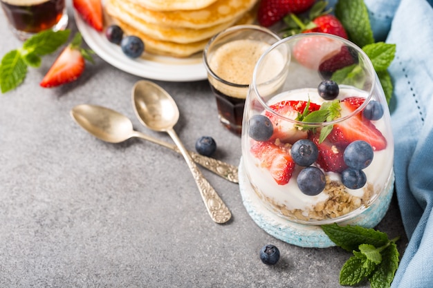 Café da manhã com granola, panquecas e frutas