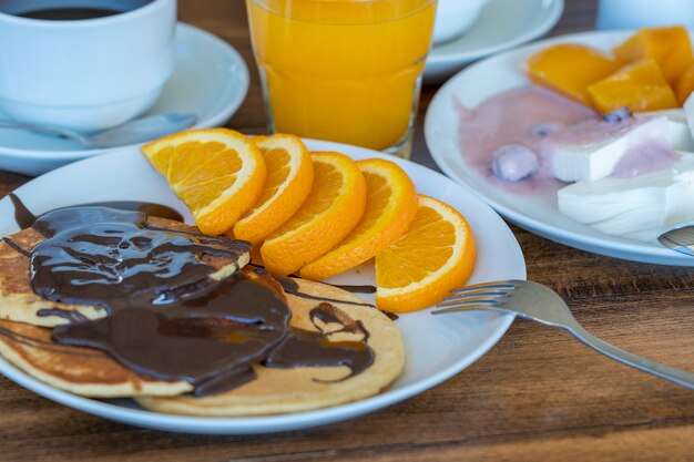 Café da manhã com muitos pratos e bebidas em uma mesa de madeira, close-up. Conceito de comida