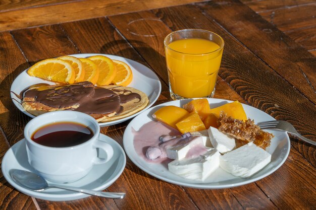 Café da manhã com muitos pratos e bebidas em uma mesa de madeira, close-up. Conceito de comida