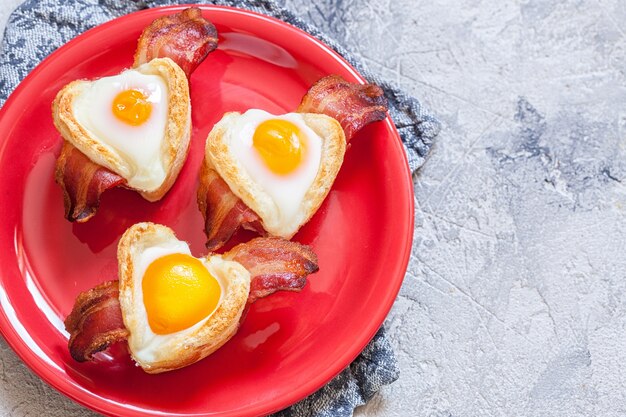 Café da manhã com ovo cozido com bacon e torradas em formato de coração para o dia dos namorados
