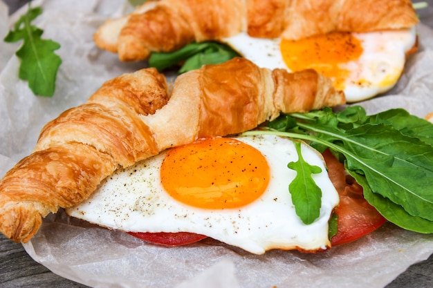 Café da manhã com ovos mexidos, croissant e rúcula