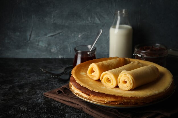 Foto café da manhã com pãezinhos de crepes em mesa fumê preta