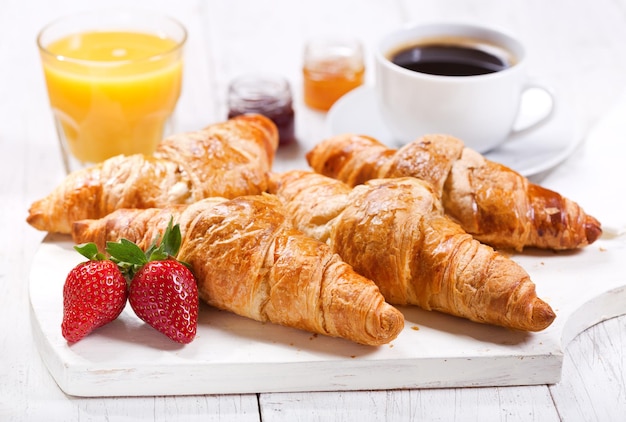 Café da manhã com suco de café croissants e frutas frescas