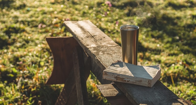 Café da manhã com um livro ao ar livre, cobertor quente, vapor em uma xícara térmica