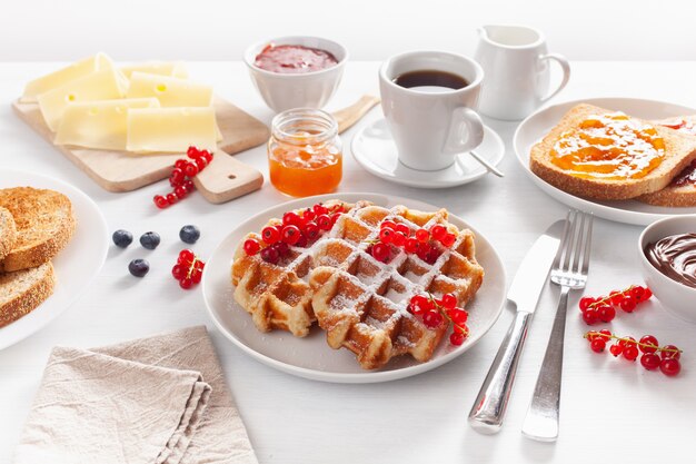 Café da manhã com waffles, torradas, bagas, geléia e café