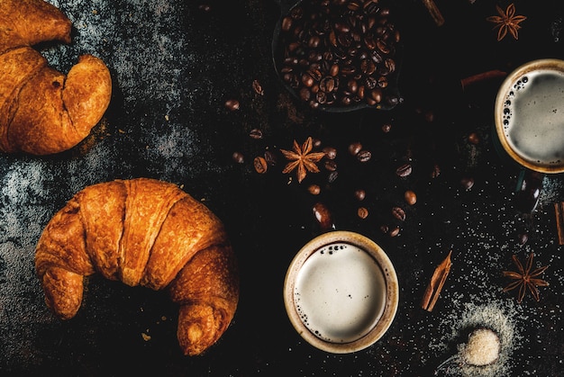 Café da manhã continental caseiro, café com especiarias, açúcar de cana, croissants. geléia em uma mesa de metal enferrujada preta, vista superior copyspace