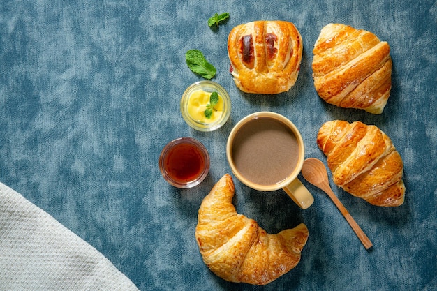 Café da manhã continental com croissants frescos, suco de laranja e café com foco seletivo