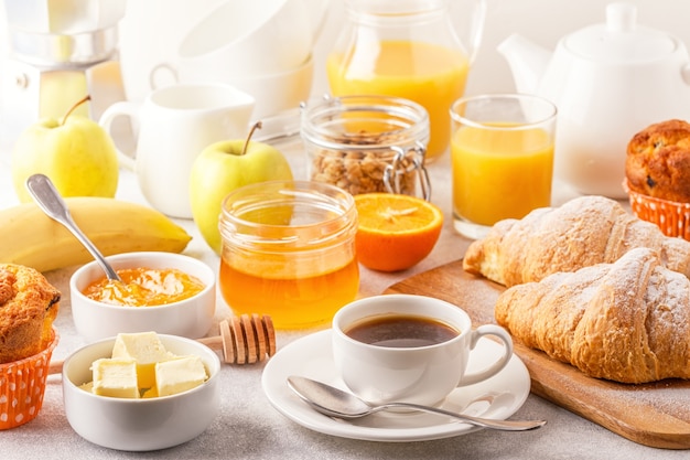 Café da manhã continental com croissants frescos, suco de laranja e café, foco seletivo.
