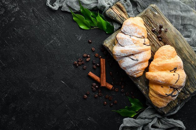 Café da manhã croissant de chocolate fresco em um fundo de pedra preta vista superior espaço livre para o seu texto