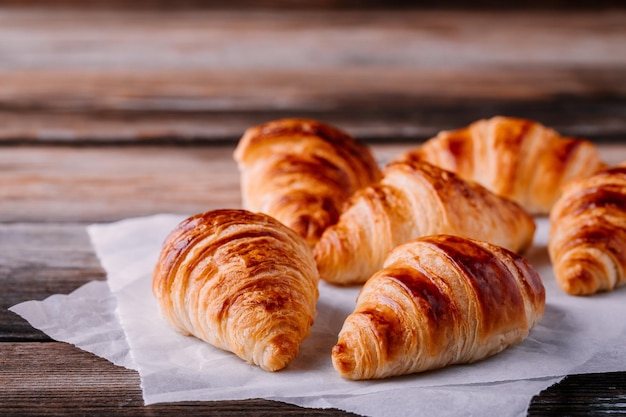 Café da manhã croissants assados caseiros em fundo rústico de madeira