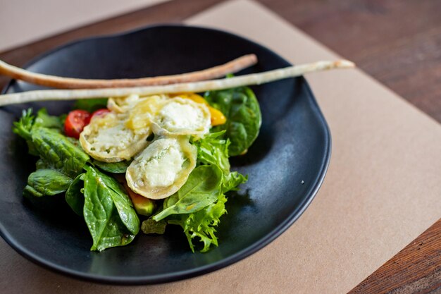 Café da manhã de manhã omelete cremosa e salada de queijo buratta abacate e folhas verdes em preto p