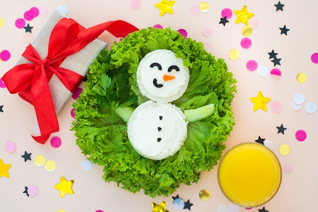 Café da manhã de Natal engraçado, sanduíches, boneco de neve com pepino.