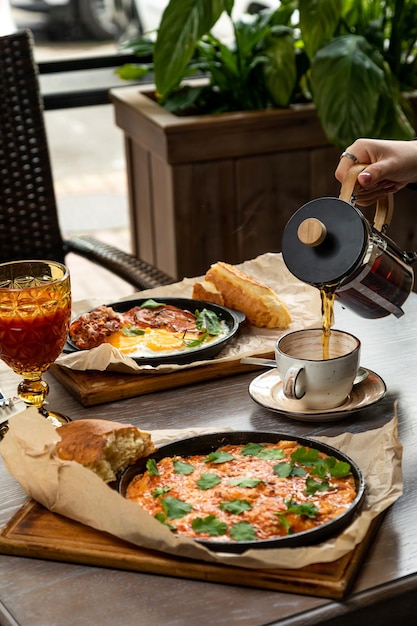 Café da manhã de omelete, ovos fritos com bacon. Servido com doces e bebidas frescas