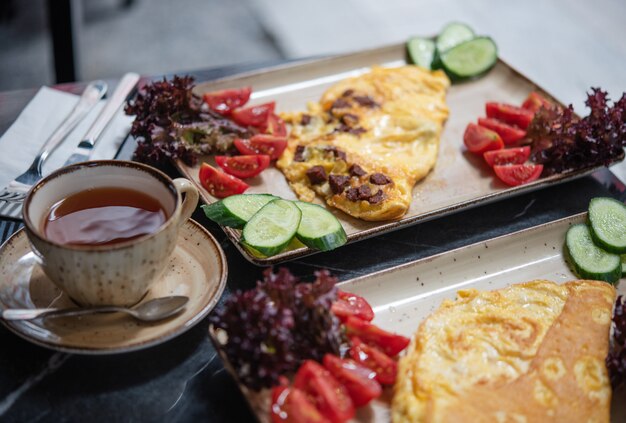 Café da manhã de verão no café. Ovos fritos com legumes frescos e uma xícara de chá