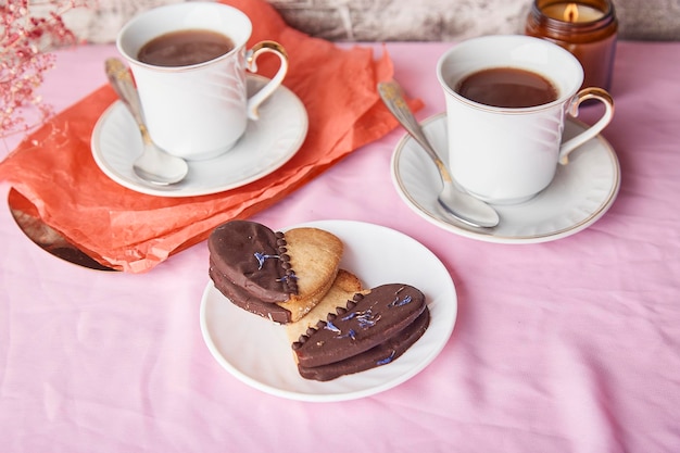 Café da manhã do Dia dos Namorados rosa lagom com biscoitos veganos em forma de coração, café e estética de velas