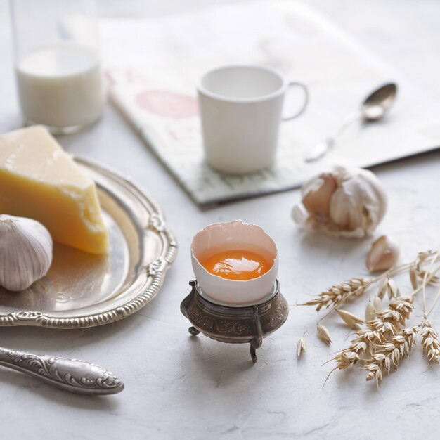 Café da manhã do país em pratos vintage em um fundo branco, ovo, queijo, alho, café