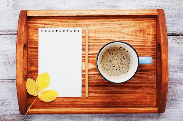 Café da manhã e caderno vazio na vista superior da bandeja de madeira Aconchegante café da manhã de outono Lista de baldes de outono