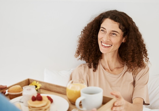 Café da manhã e mulher na cama para comemoração de aniversário de aniversário e gesto romântico Relação amor e casal feliz com comida saudável na bandeja para bem-estar nutrição e surpresa