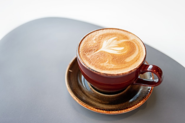 Café da manhã em uma xícara de cerâmica com espuma em um pires.