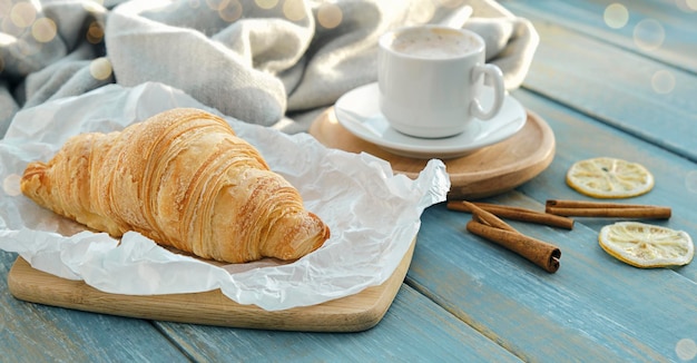 Café da manhã francês com croissants e café em fundo de madeira.
