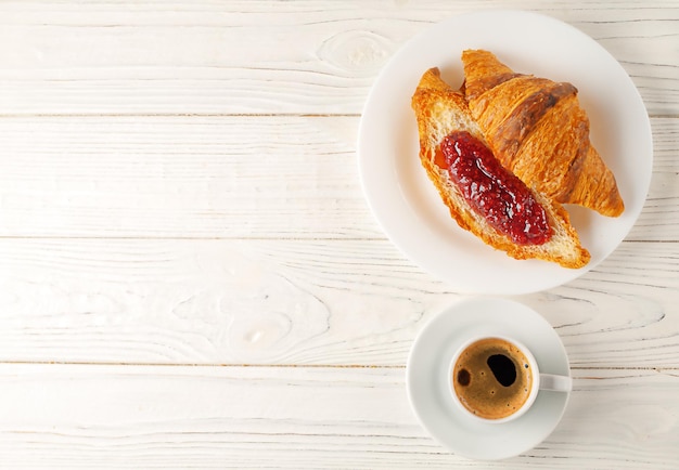 Café da manhã francês deliciosos croissants frescos com geleia e uma chávena de café