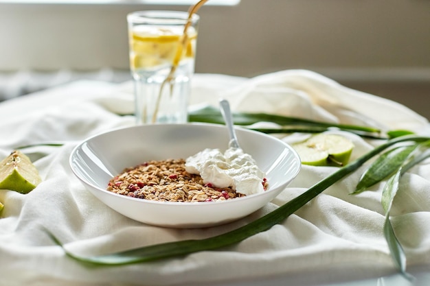 Café da manhã granola com iogurte grego e copo de água detox