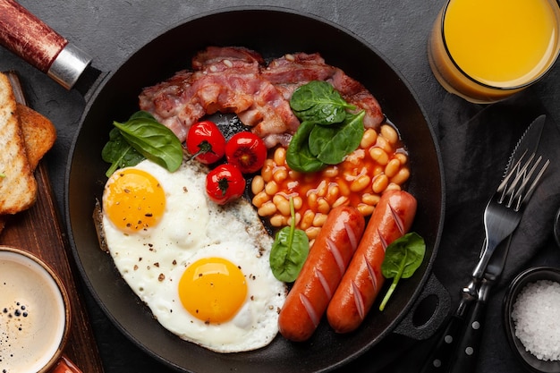 Café da manhã inglês com bacon e salsichas dos feijões dos ovos fritos