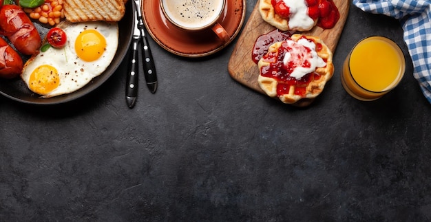 Café da manhã inglês com bacon e salsichas dos feijões dos ovos fritos