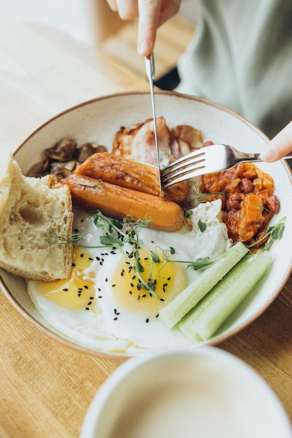 Café da manhã inglês com ovos de salsichas e legumes servidos em um café