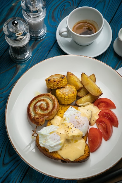 Café da manhã inglês com torradas, ovo pochê, molho e linguiça em mesa de madeira