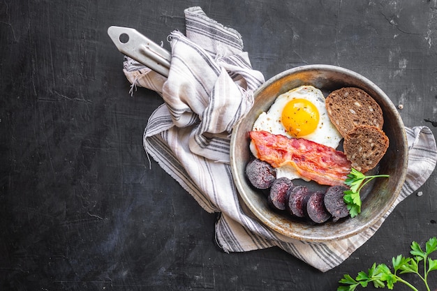 Café da manhã inglês morcela ovo frito linguiça de sangue cereal pão feijão ovos mexidos na mesa