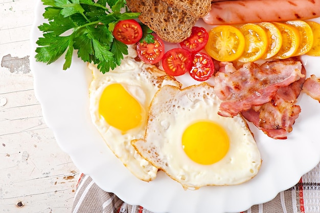Café da manhã inglês ovos fritos bacon salsichas e pão de centeio torrado