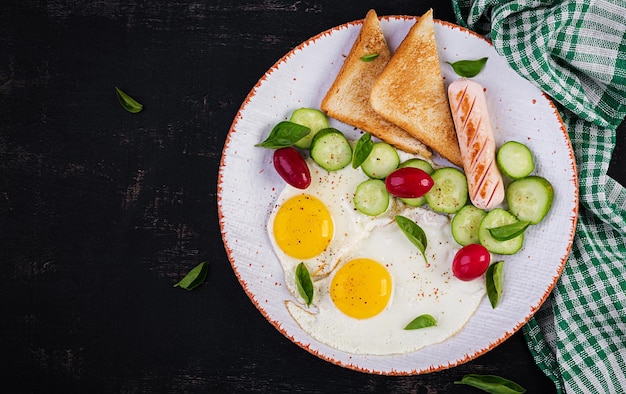 Café da manhã inglês ovos fritos salsicha pepino e torradas Comida americana Vista de cima postura plana