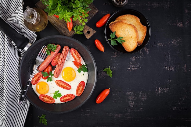 Café da manhã inglês, ovos fritos, tomates, salsichas e torradas.
