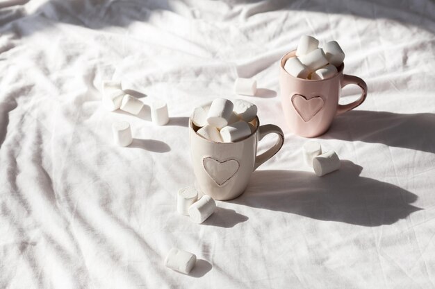 Café da manhã na cama para casais composição plana pastel com xícaras de café e doce marshmallow. Mulher de conceito ou dia dos namorados.