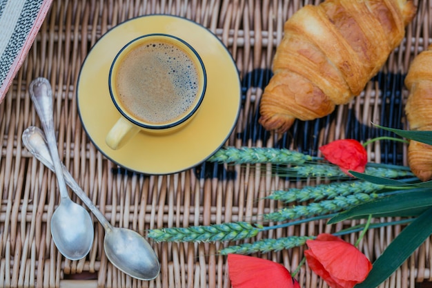 Café da manhã na grama. Xícara de café e croissants franceses. Fundo de encontro romântico