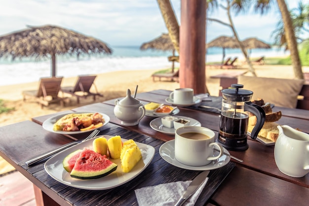 Café da manhã na praia no Sri Lanka Cenário de mesa com comida vegana e café no restaurante ao ar livre