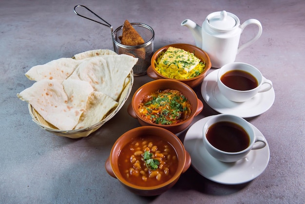 Café da manhã no Bahrein com café de pão de feijão hummus servido em prato isolado em fundo cinza vista superior da comida do Bahrein