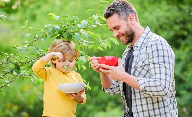 Café da manhã no fim de semana. alimentação e dieta saudáveis. Lacticínios. filho e pai comendo ao ar livre. Família feliz junto. Feliz dia dos pais. O menino com o pai come cereais. Saúde em suas mãos.