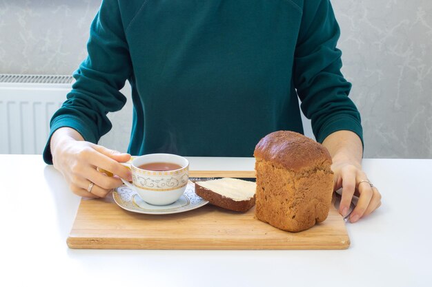 Café da manhã no fundo de madeira com chá com limão e pão com manteiga