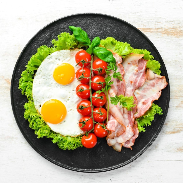 Café da manhã Ovos fritos com bacon e tomate cereja Vista superior Espaço livre para o seu texto