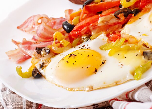 Café da manhã - ovos fritos com bacon, tomate, azeitona e fatias de queijo