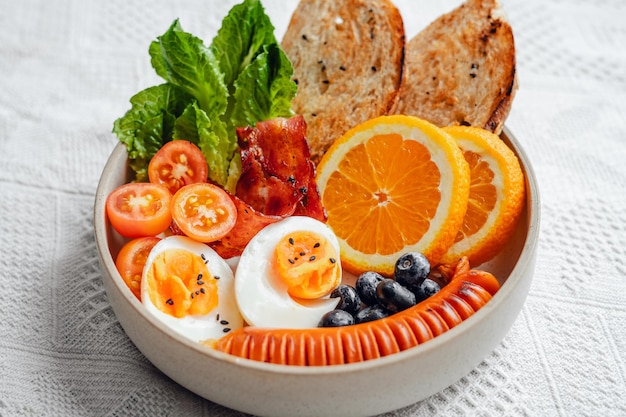 Café da manhã pão bacon ovos cozidos e frutas e legumes