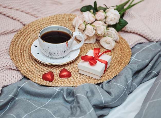 Café da manhã romântico com café, caixa de presente e flores rosas.