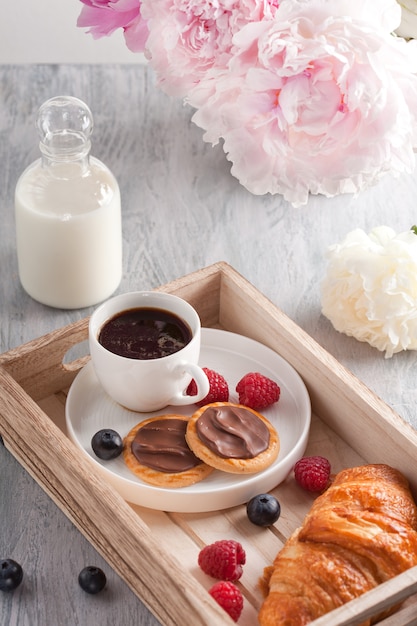 Café da manhã romântico com café, croissant, biscoitos de chocolate e frutas silvestres