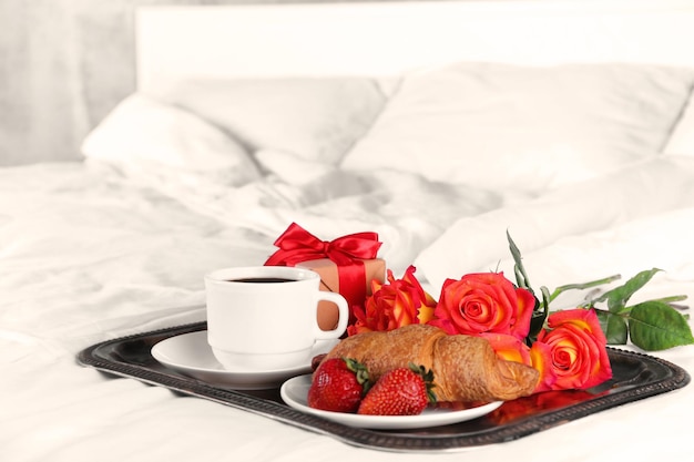 Café da manhã romântico com café, morango e croissant na bandeja no quarto conceito de lua de mel