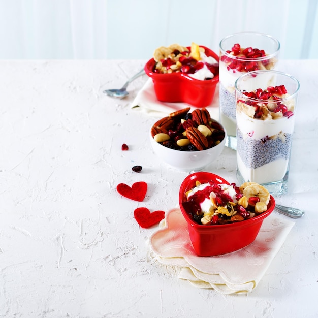 Café da manhã romântico com iogurte de granola chia e bagas no velho fundo de concreto branco Conceito de saúde e dieta